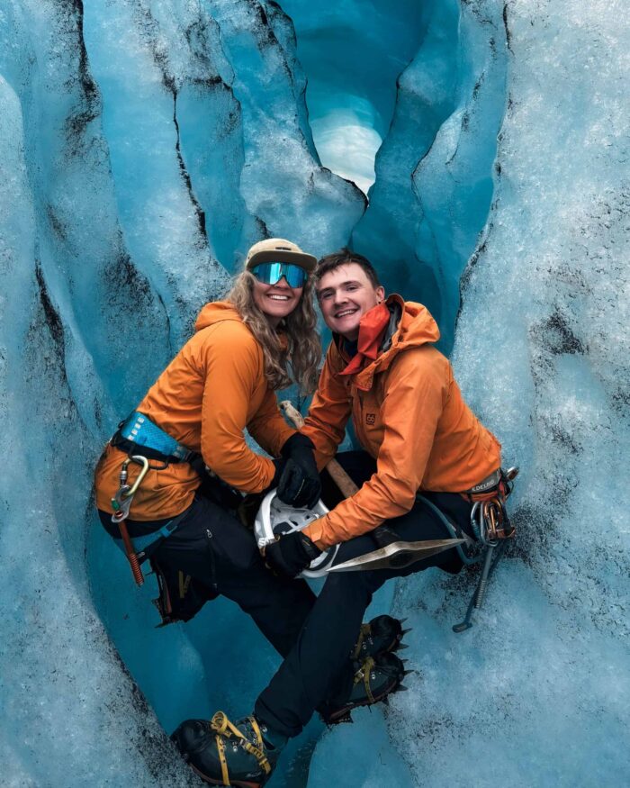 Owners of Layover together in a bright blue glacial ice cave